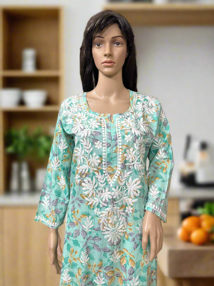 Mannequin wearing a floral dress in a fabric store with shelves of fabric in the background.