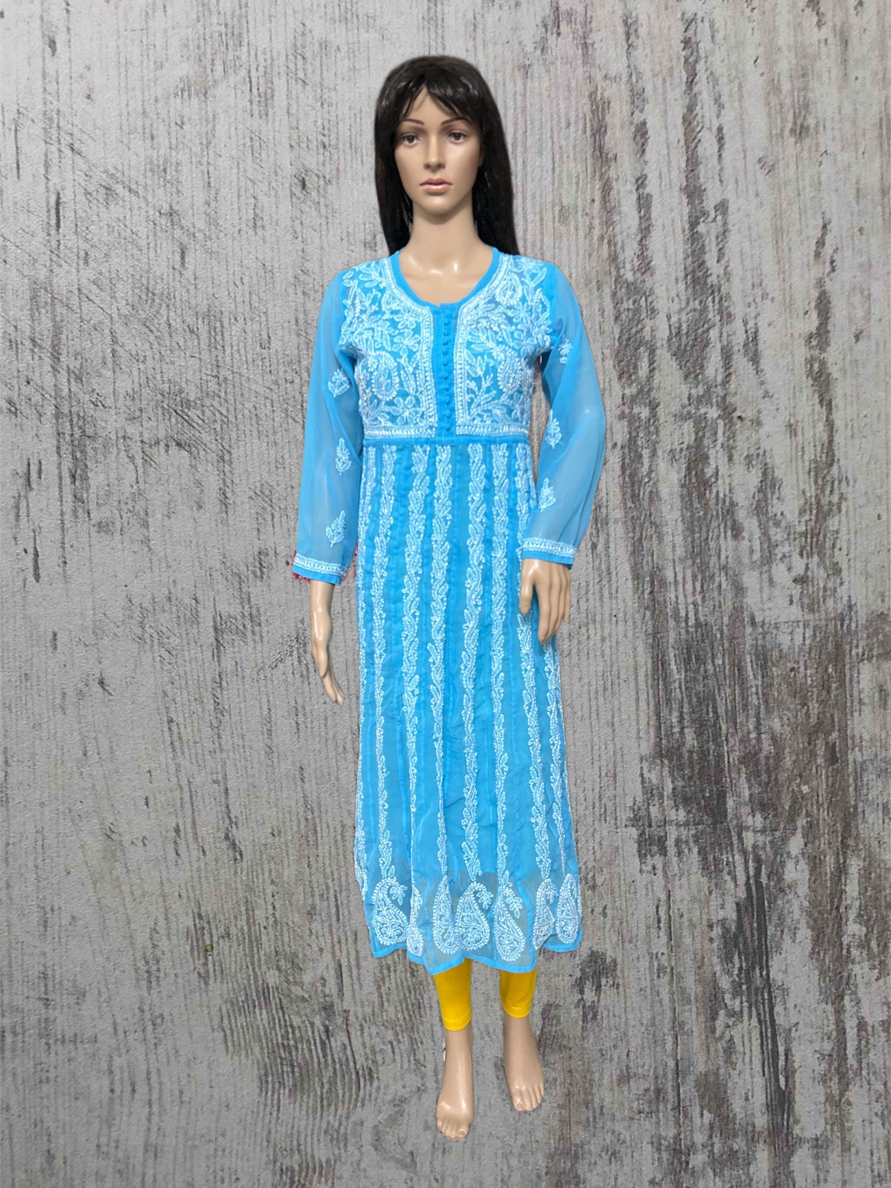 Mannequin wearing a blue embroidered dress on a textured gray background