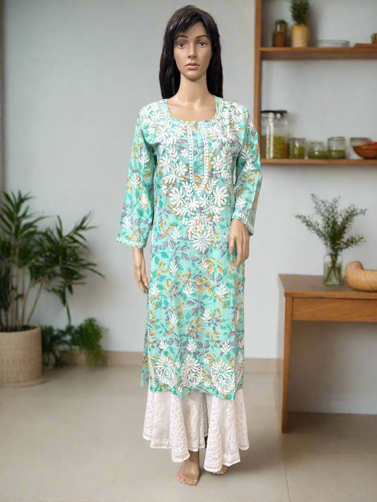 Mannequin wearing a floral dress in a fabric store with shelves of fabric in the background.