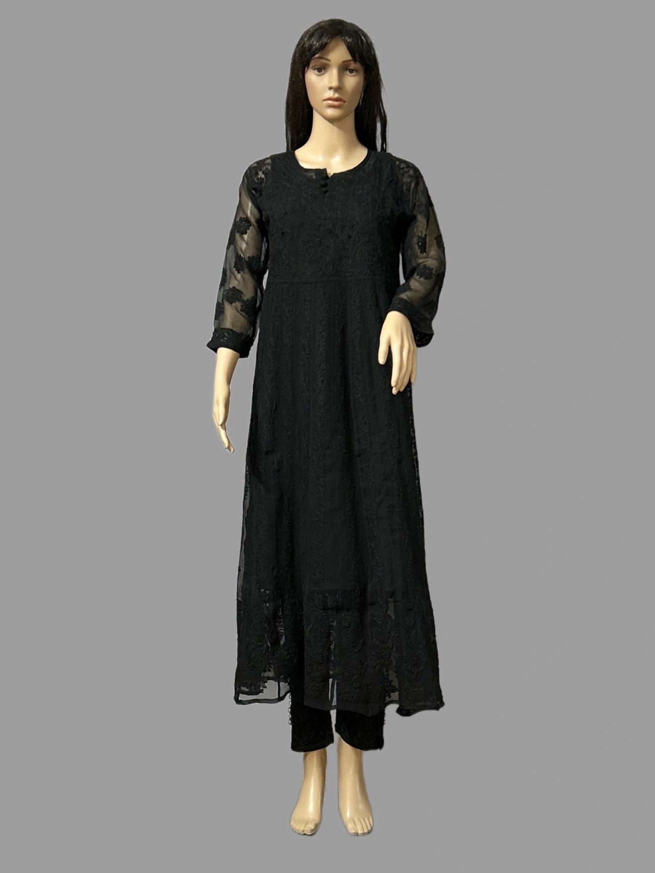 Black dress with sheer sleeves on a mannequin against a gray background