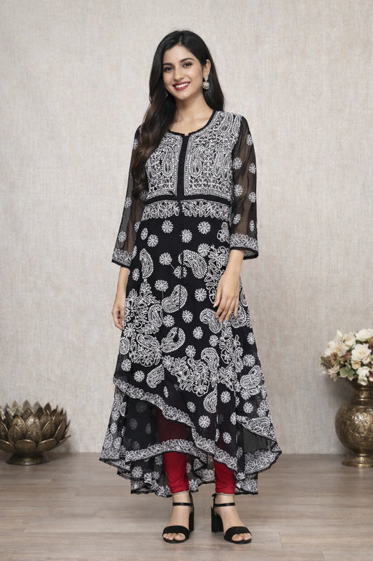 Woman wearing a black and white patterned dress standing against a neutral background