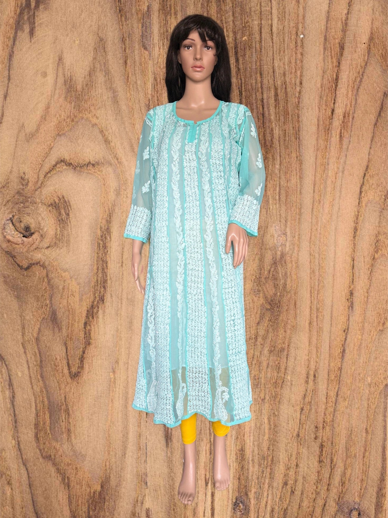 Green kurta with white floral embroidery on a beige background