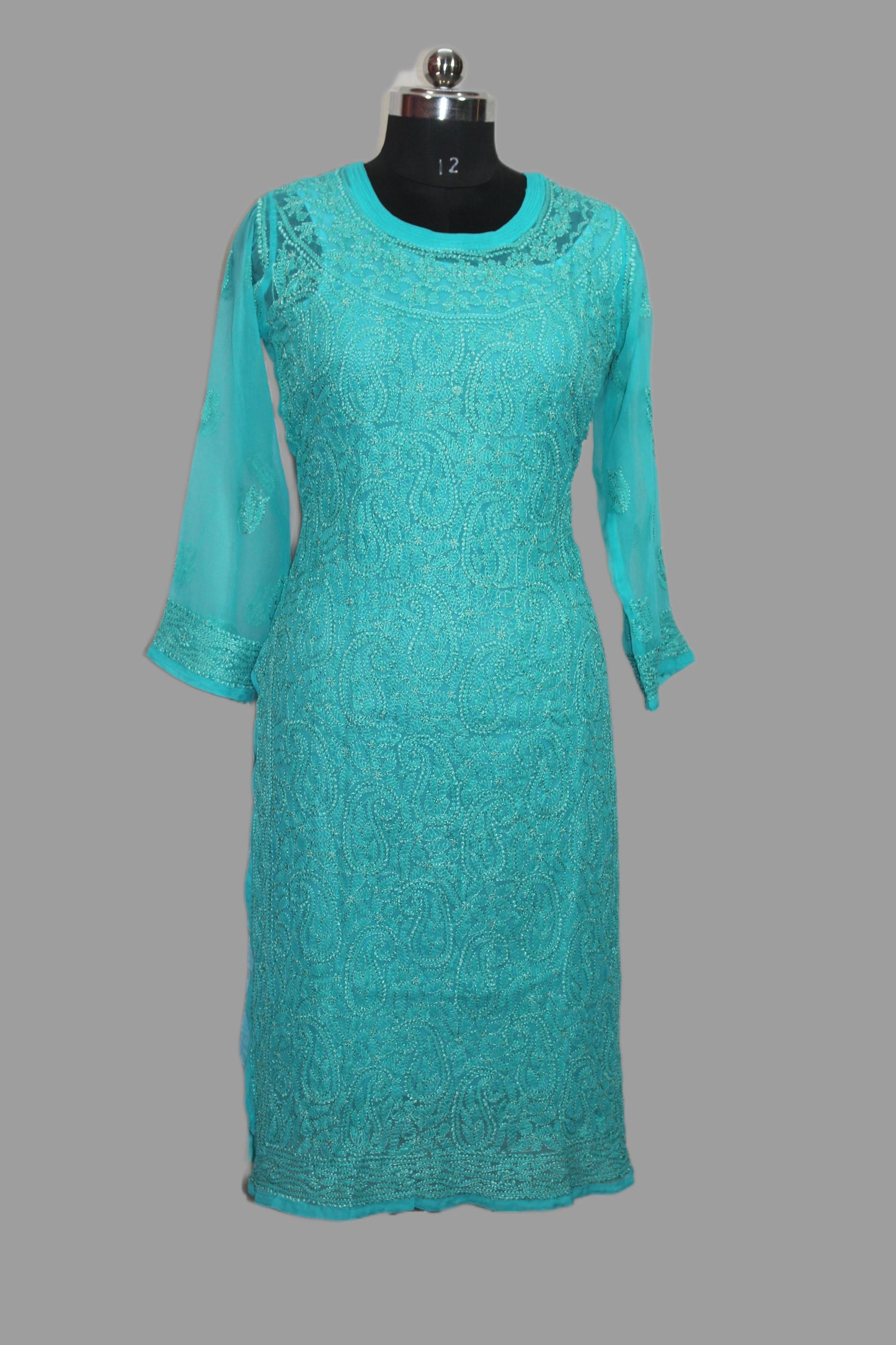 Teal lace dress on a mannequin against a gray background
