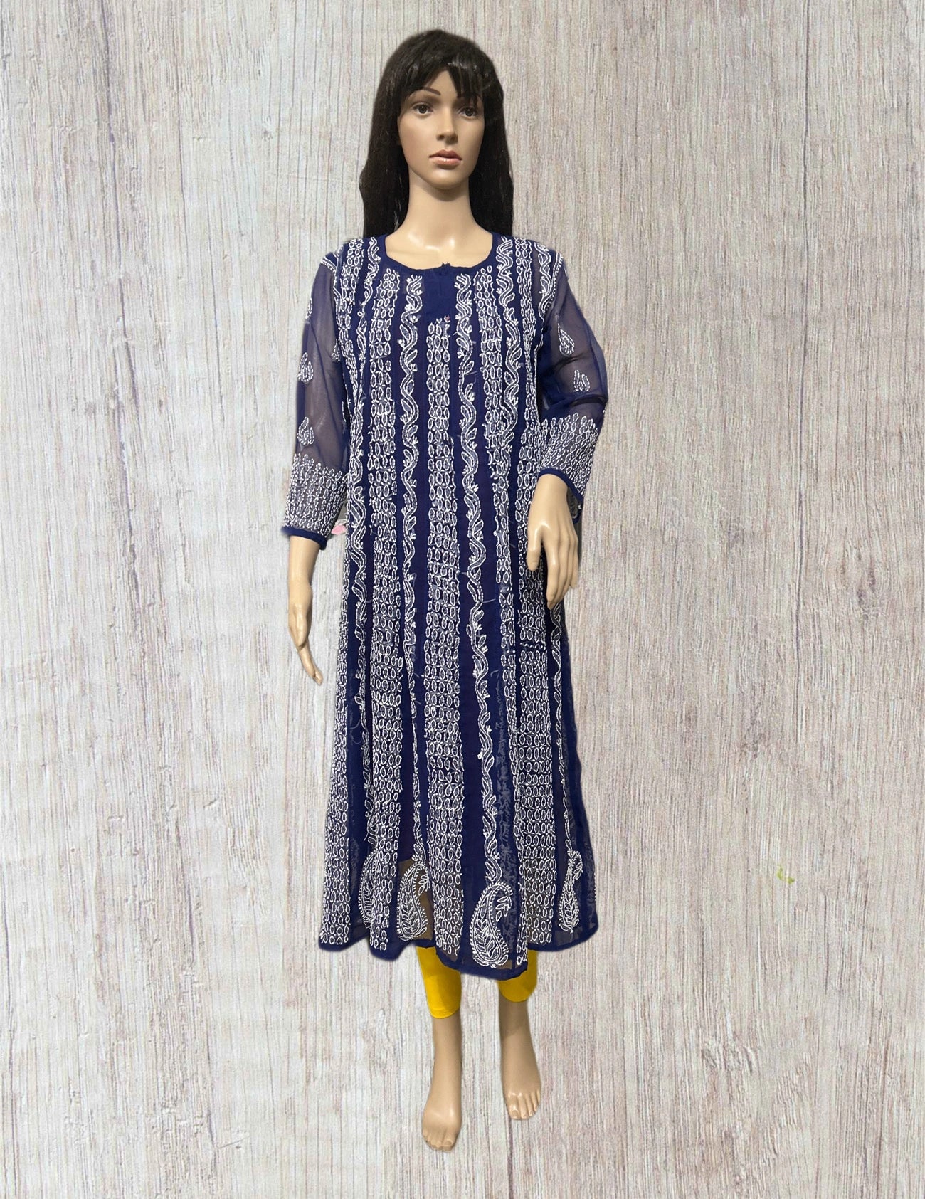 Blue hand embroidered anarkali kurta on a mannequin against a wooden background