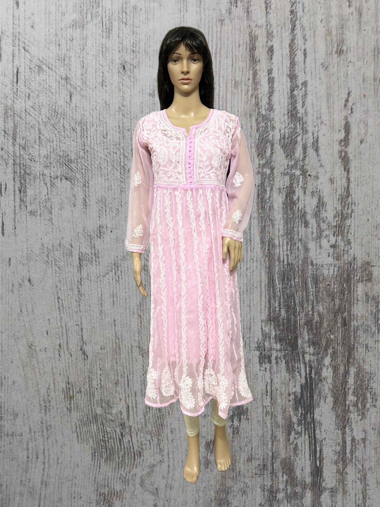 Mannequin wearing a pink lace dress against a textured gray background