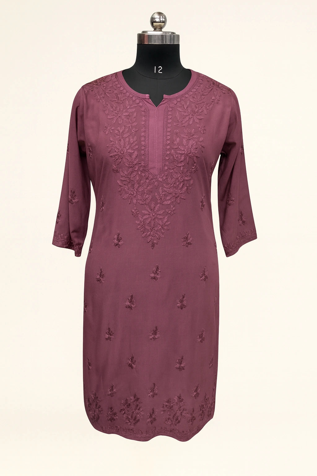 Mauve dress with floral embroidery on a mannequin against a white background