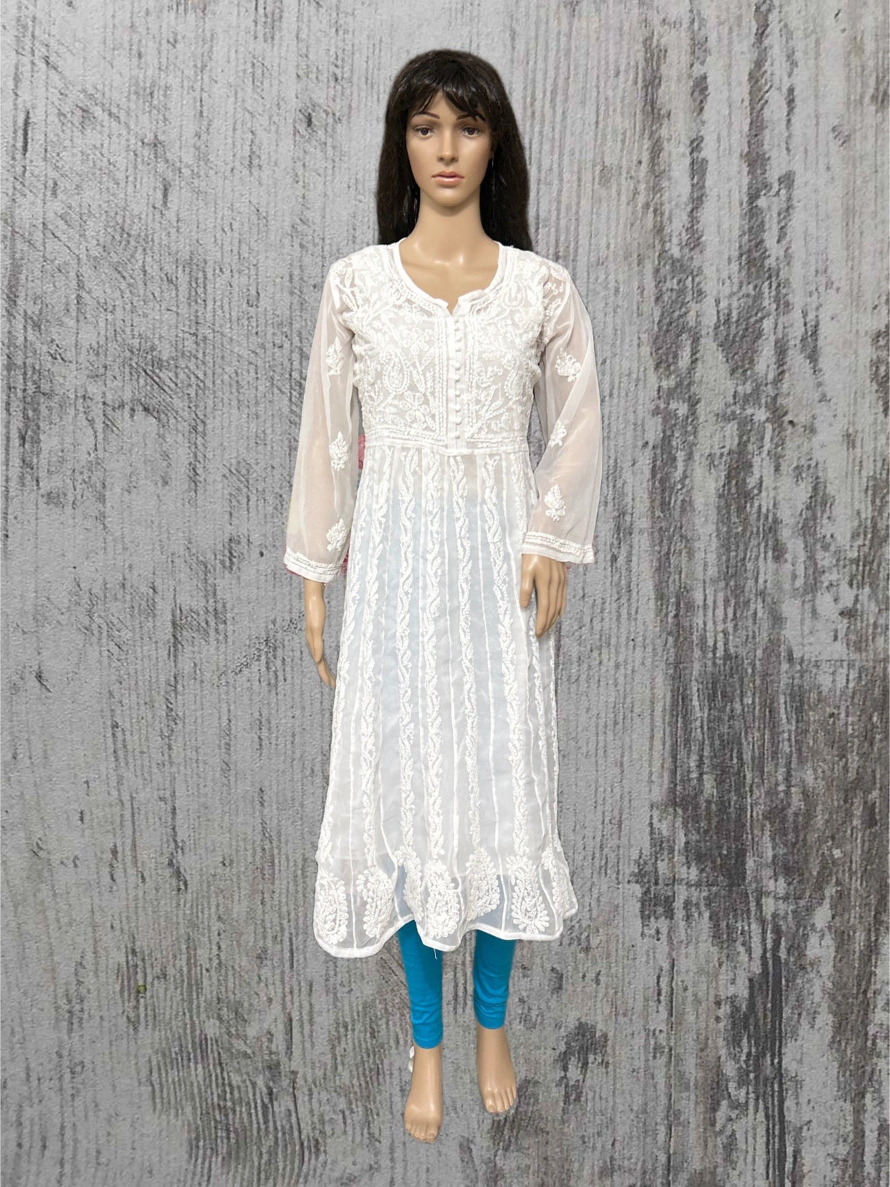 lucknowi chikankari White lace dress on a mannequin against a textured gray background