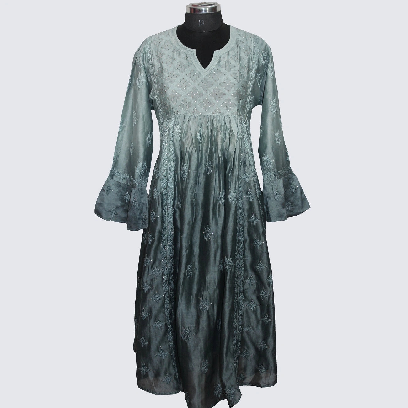 Green dress on a mannequin against a white background