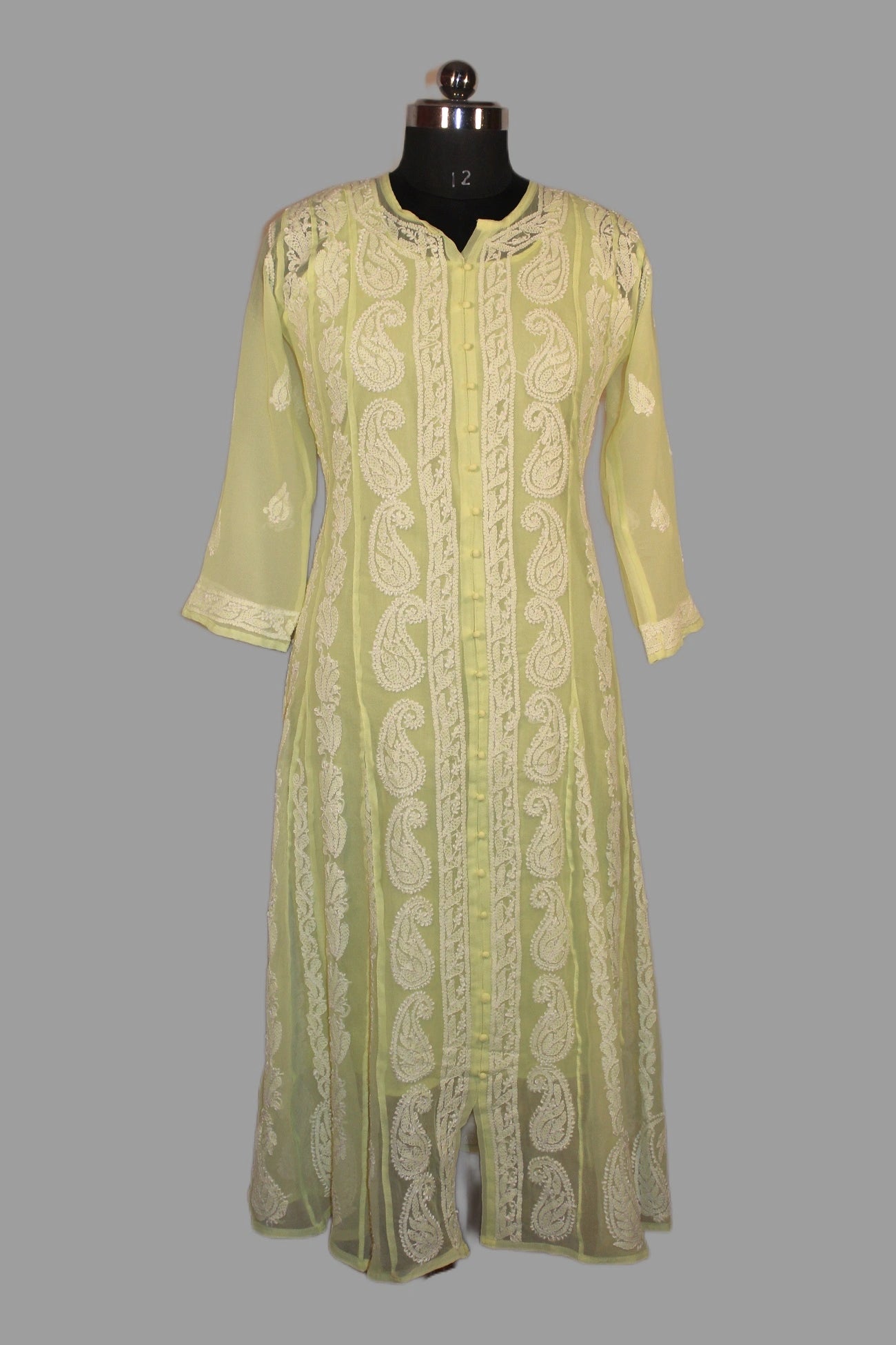 Light green embroidered kurta on a mannequin against a gray background