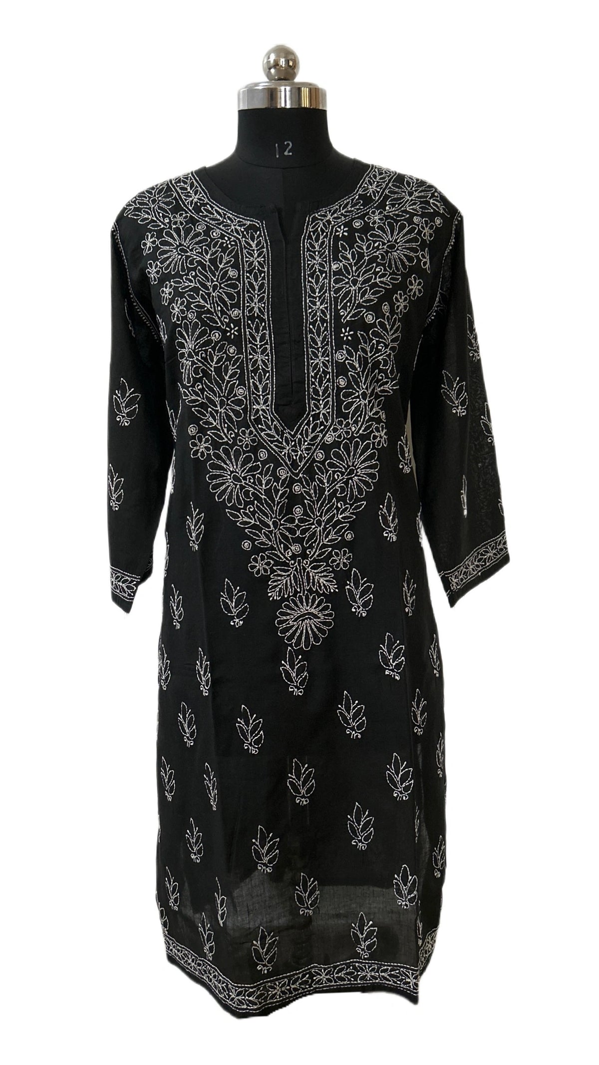 A black three-quarter sleeve kurta with intricate silver floral embroidery, displayed on a black dress form mannequin against a plain white background.