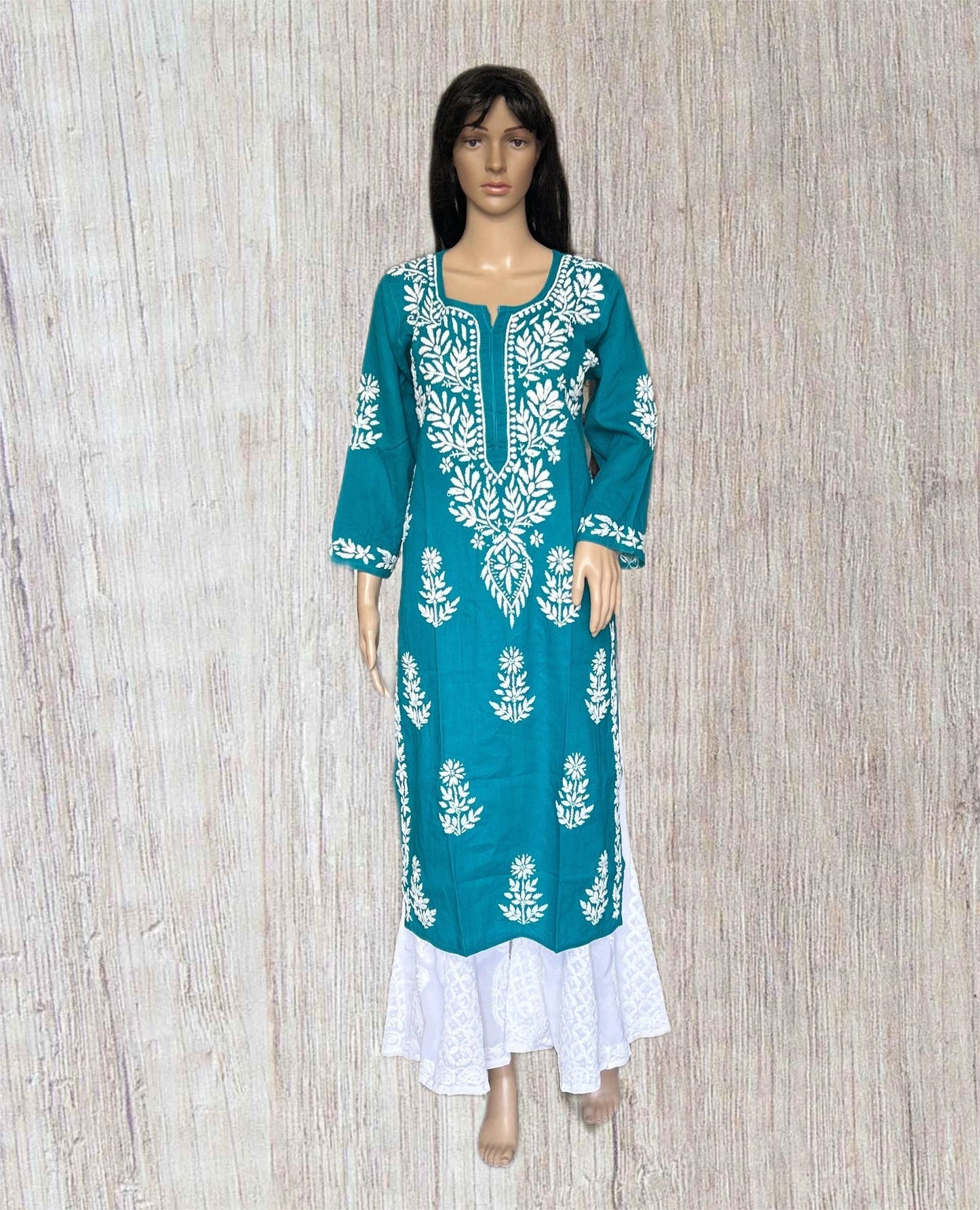 Teal dress with white floral patterns on a wooden background