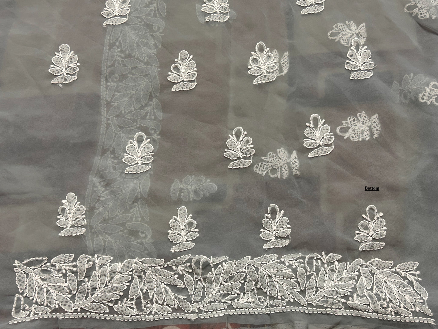 Dark fabric with intricate white floral embroidery