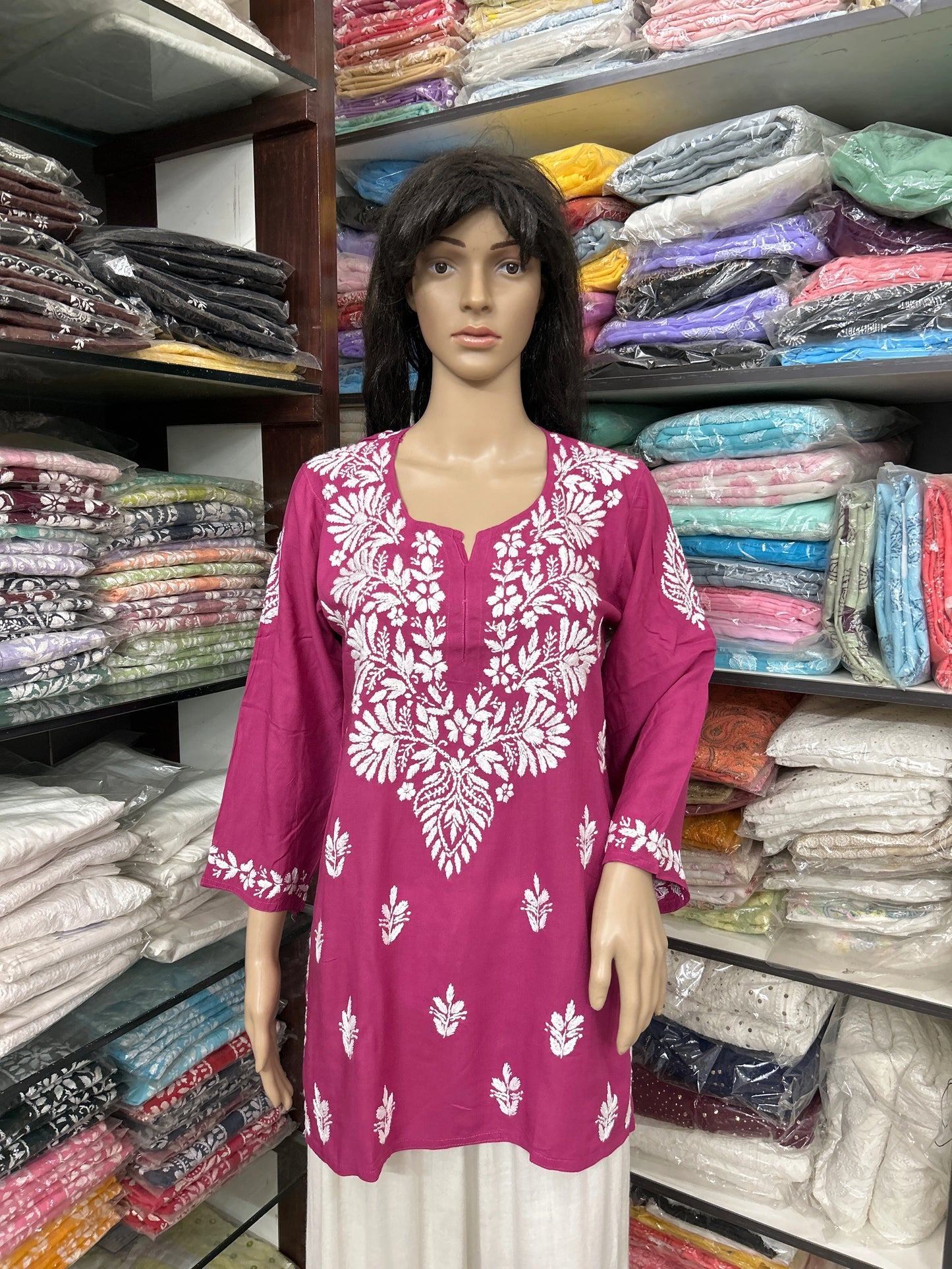 Mannequin wearing a pink embroidered top in a fabric store
