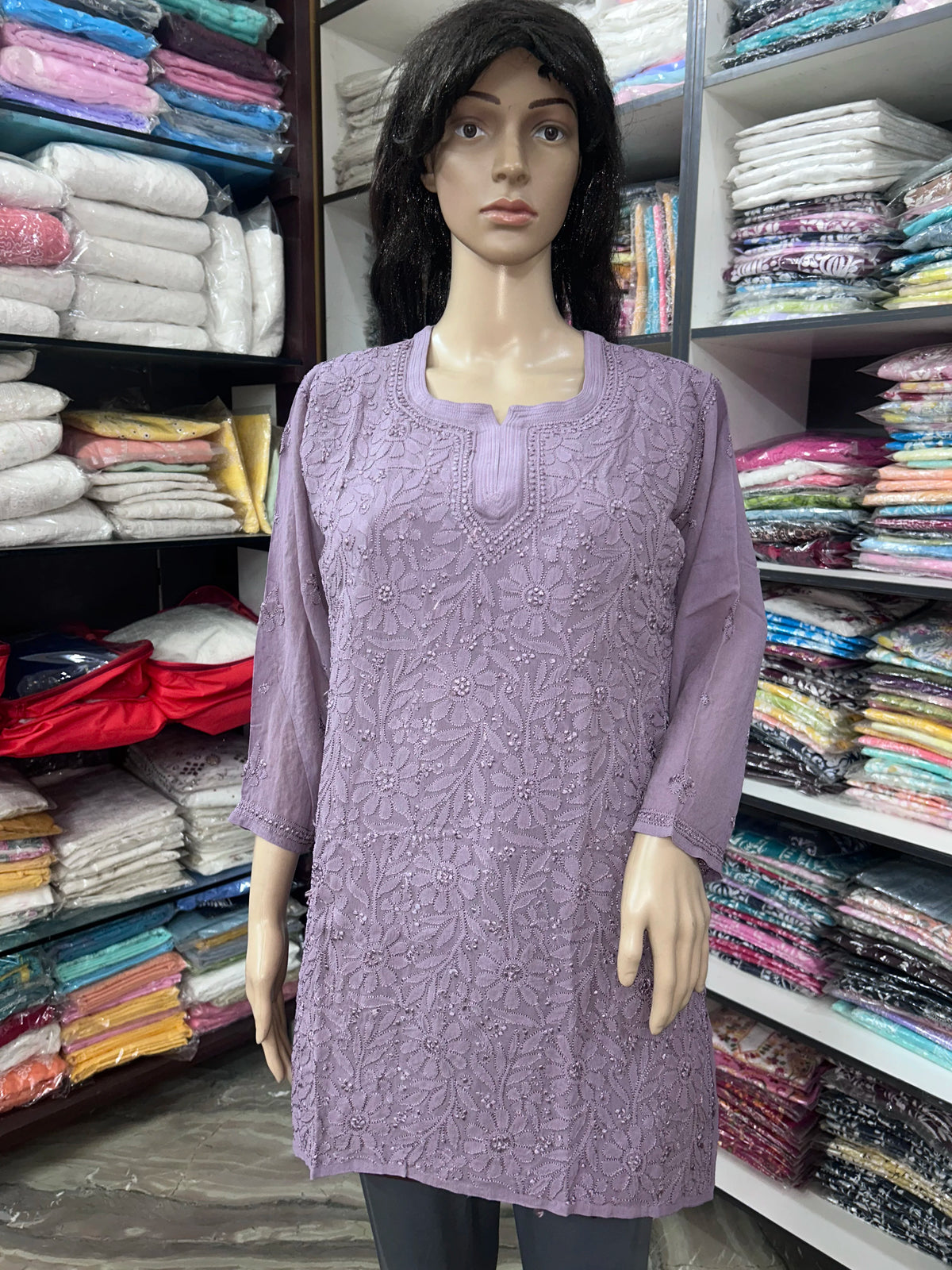 Woman wearing a lucknowi chikankari mauve-colored kurta with white patterns on a white background
