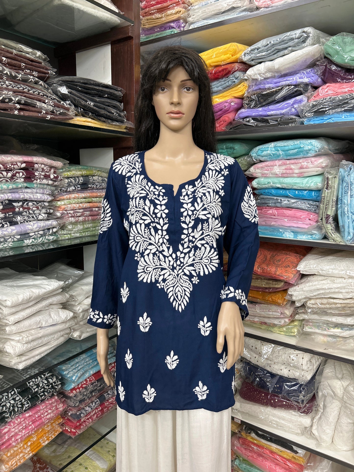 Mannequin wearing a lucknowi chikankari blue top in a fabric store.