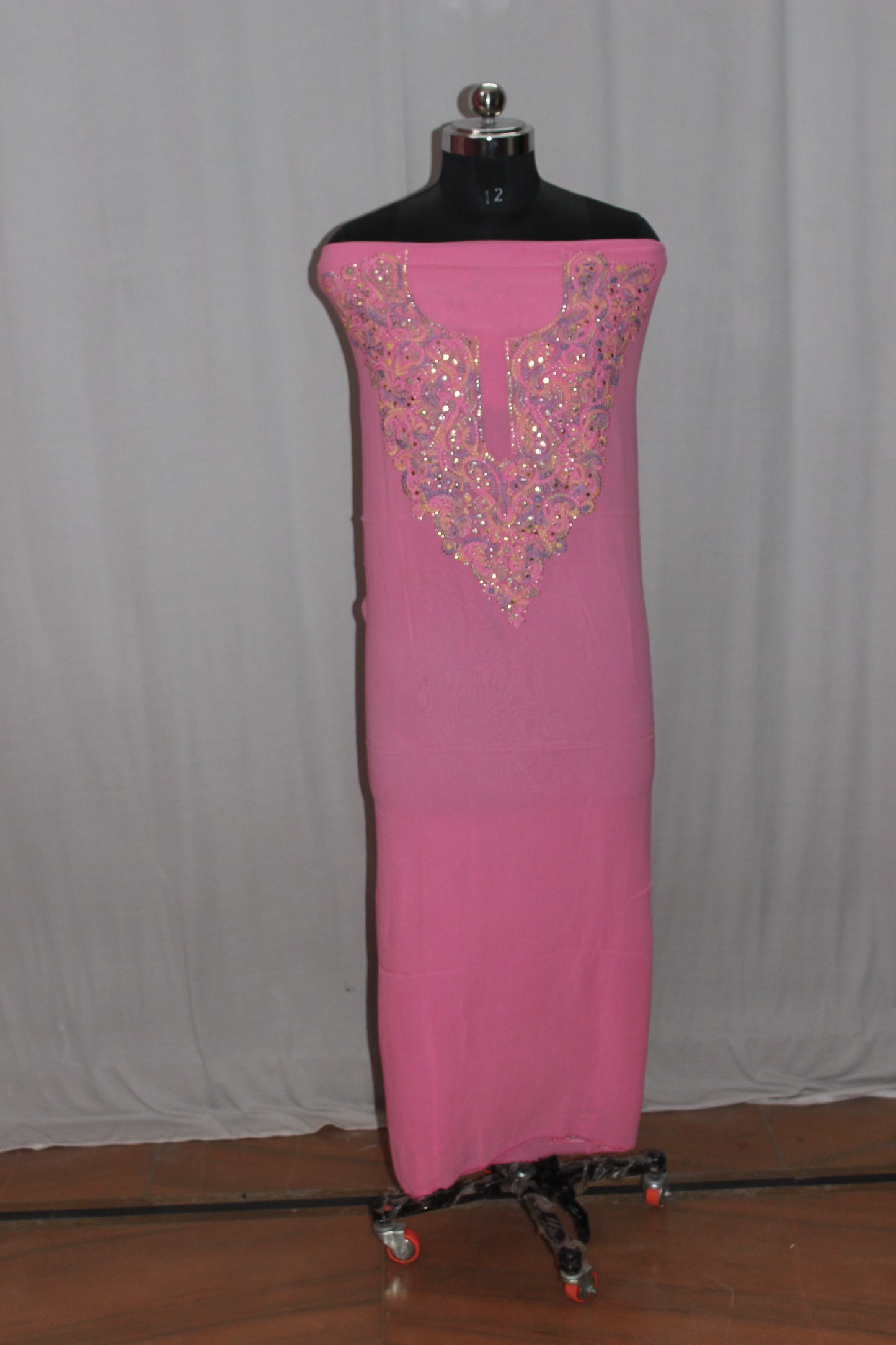 lucknowi chikankari Pink dress with intricate beading on a mannequin against a plain background