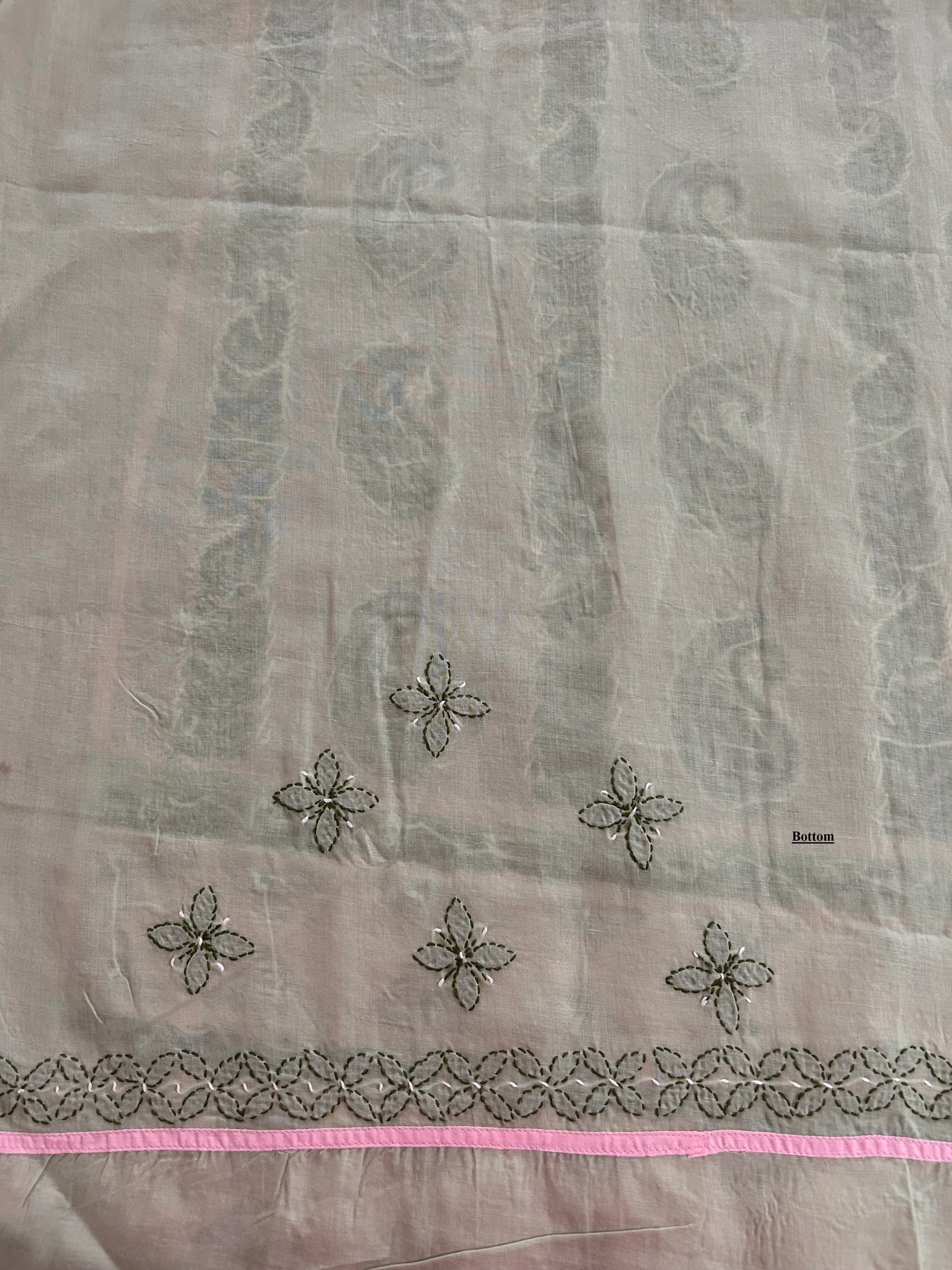Sheer fabric with floral embroidery and pink border on a light gray background