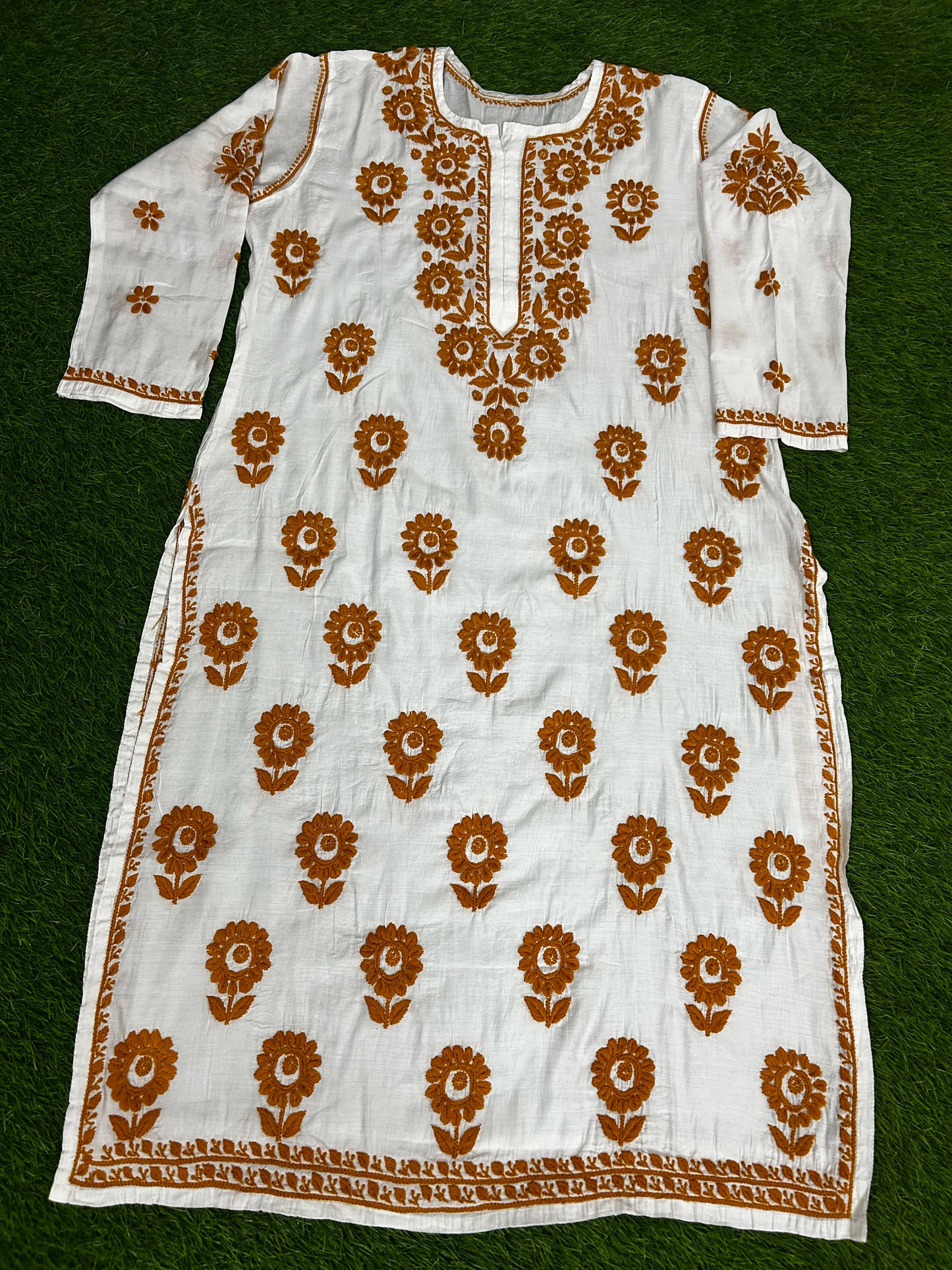 lucknowi chikankari White kurta with brown floral patterns on a green background