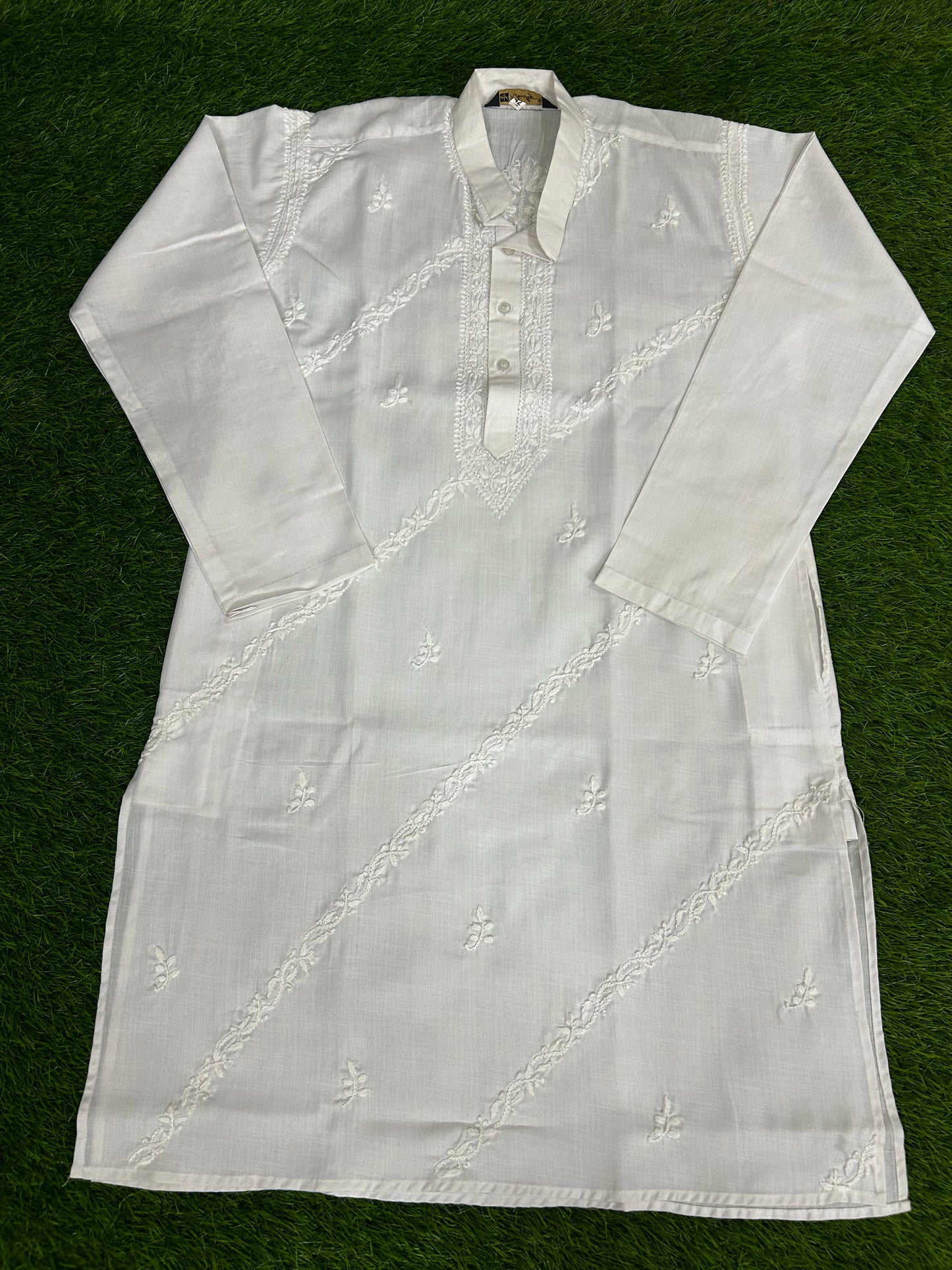 White embroidered kurta on a green background
