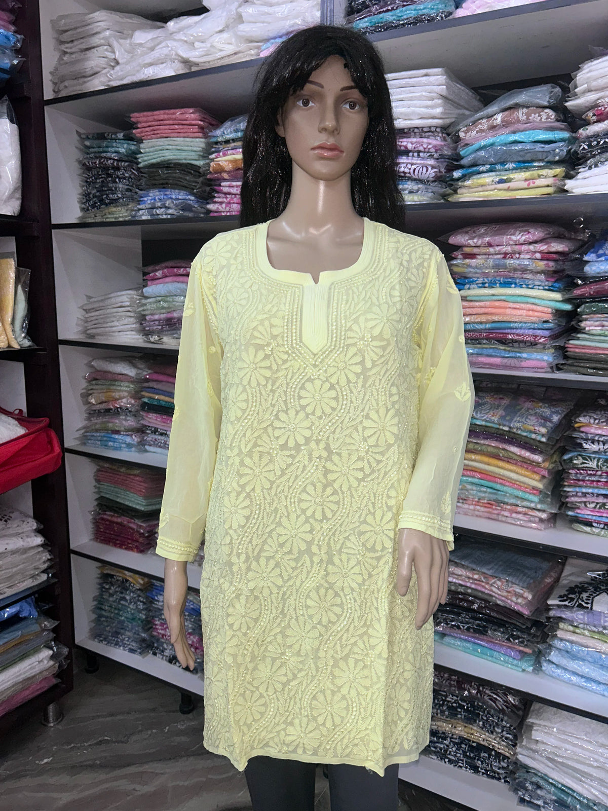 Woman wearing a lucknowi chikankari yellow-colored kurta with white patterns on a white background