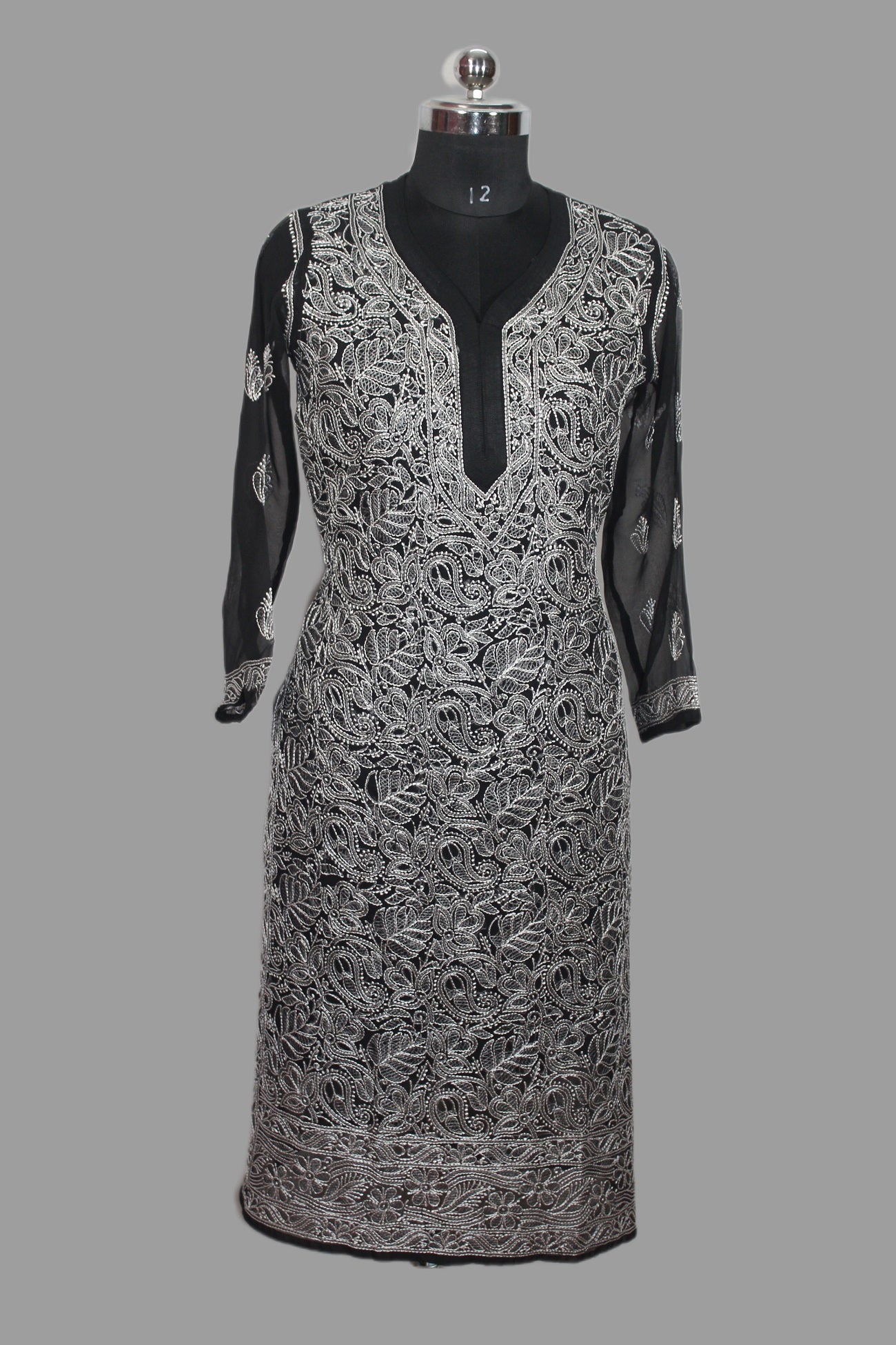 Black and white patterned dress on a mannequin against a gray background