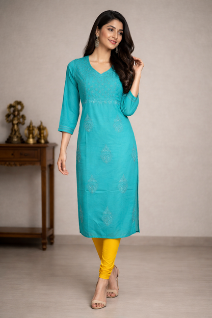 Woman wearing a turquoise kurta with yellow pants in a neutral setting