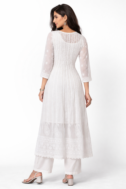 Woman wearing a white dress with sheer sleeves on a white background