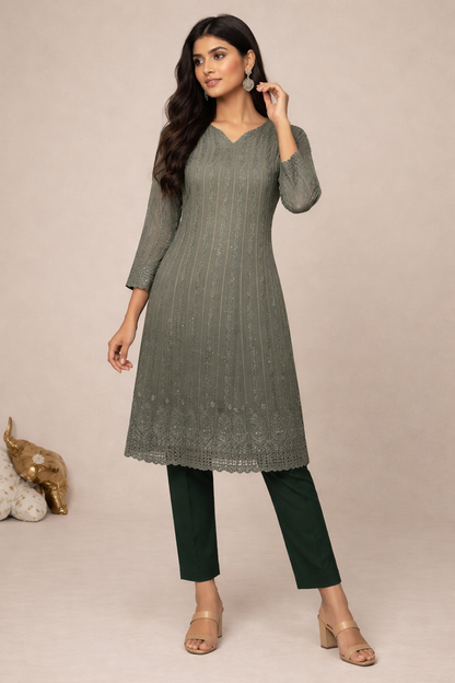 Woman wearing a green kurta with black pants against a beige background