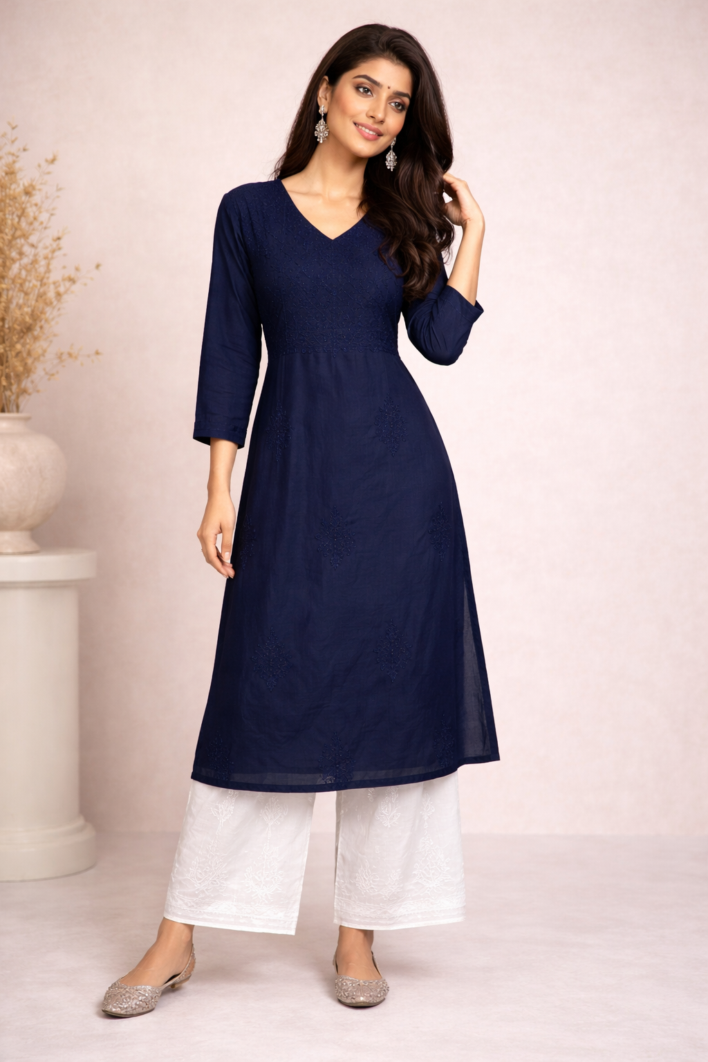 Woman wearing a navy blue kurta with white pants on a light background