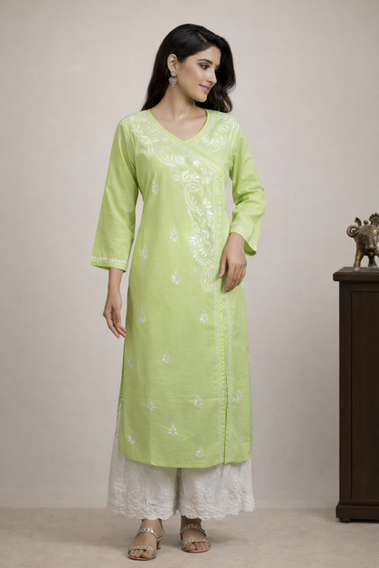 Woman wearing a light green kurta with white embroidery against a beige background