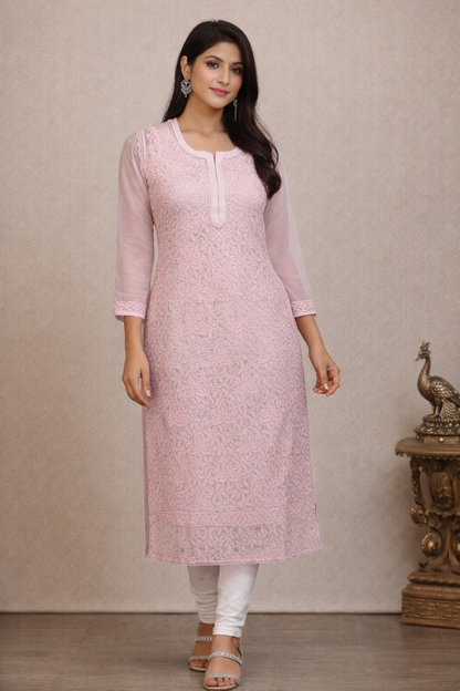Woman wearing a pink kurta with white pants against a beige background