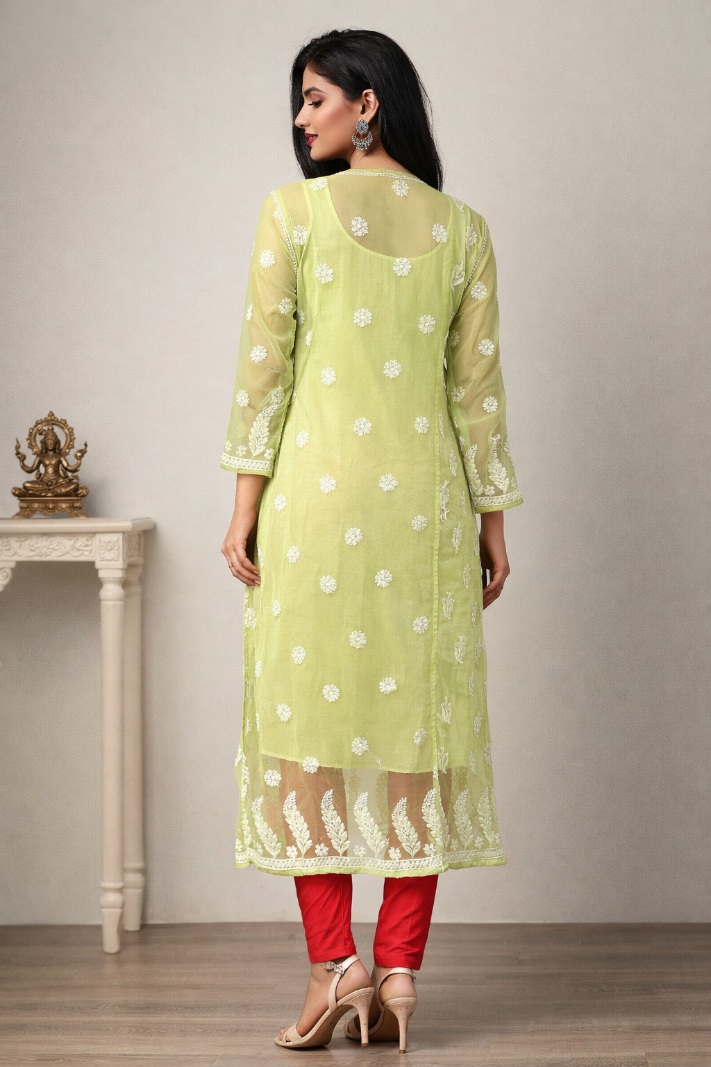 Woman wearing a light green kurta with white patterns and red pants, standing against a neutral background.