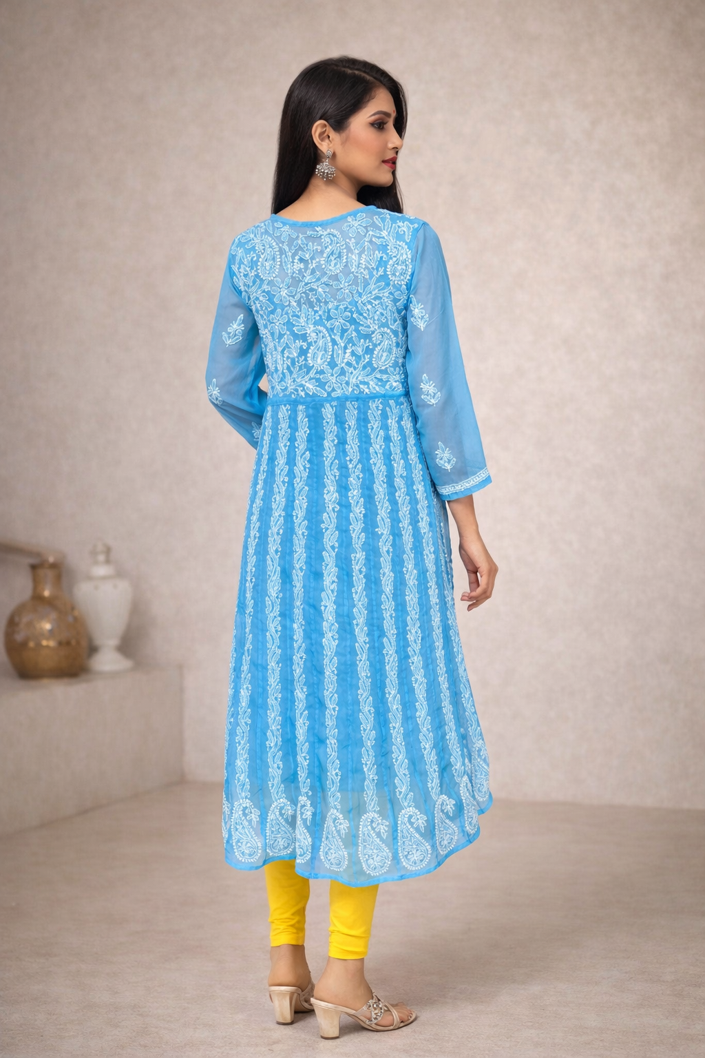 Woman wearing a light blue embroidered kurta with yellow pants in a neutral setting