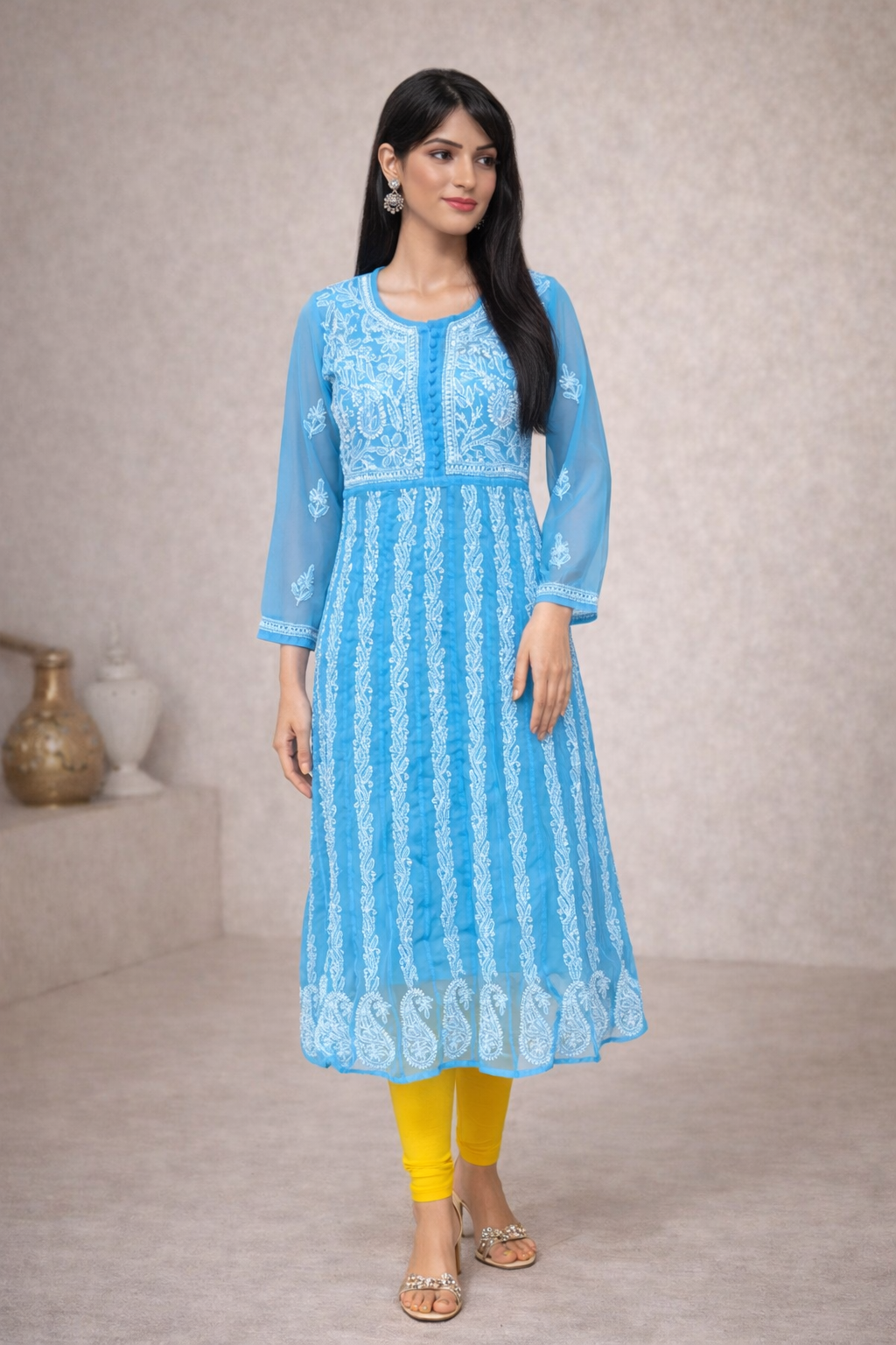 Woman wearing a blue embroidered kurta with yellow pants against a neutral background