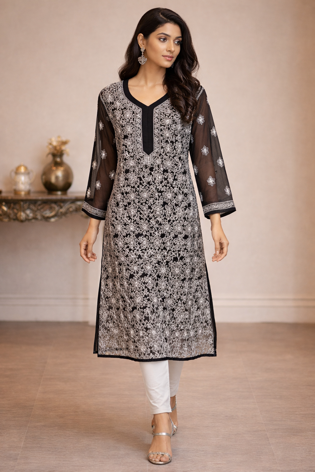 Woman wearing a black and white floral kurta with sheer sleeves in an indoor setting.
