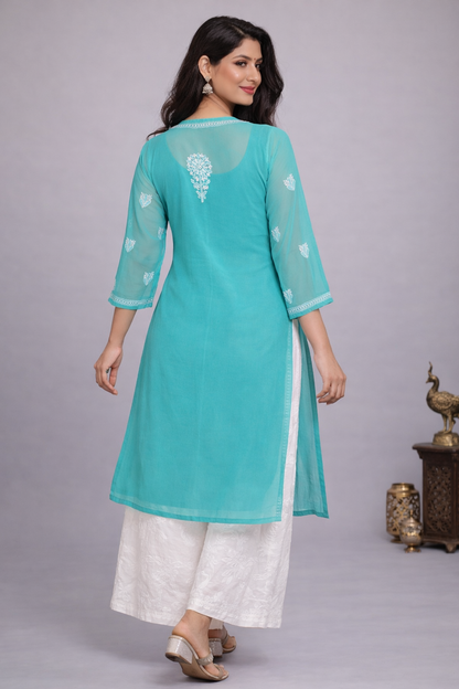 Woman wearing a turquoise and white traditional outfit on a gray background