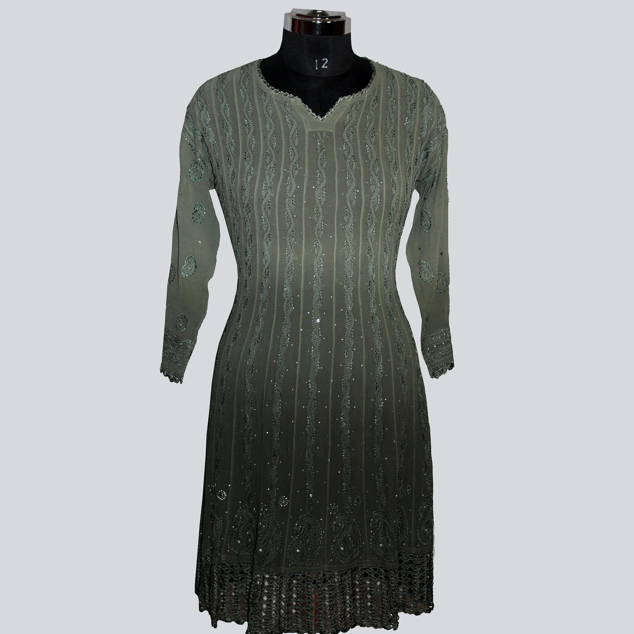 Green dress on a mannequin against a gray background