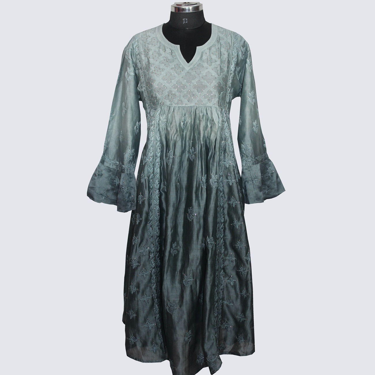 Green dress on a mannequin against a white background