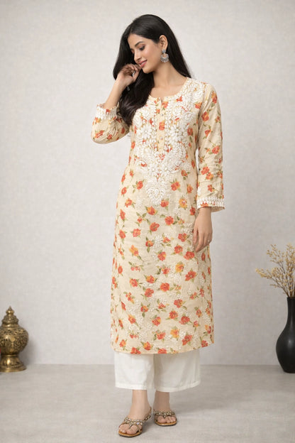 Woman wearing a floral kurta with white pants against a plain background