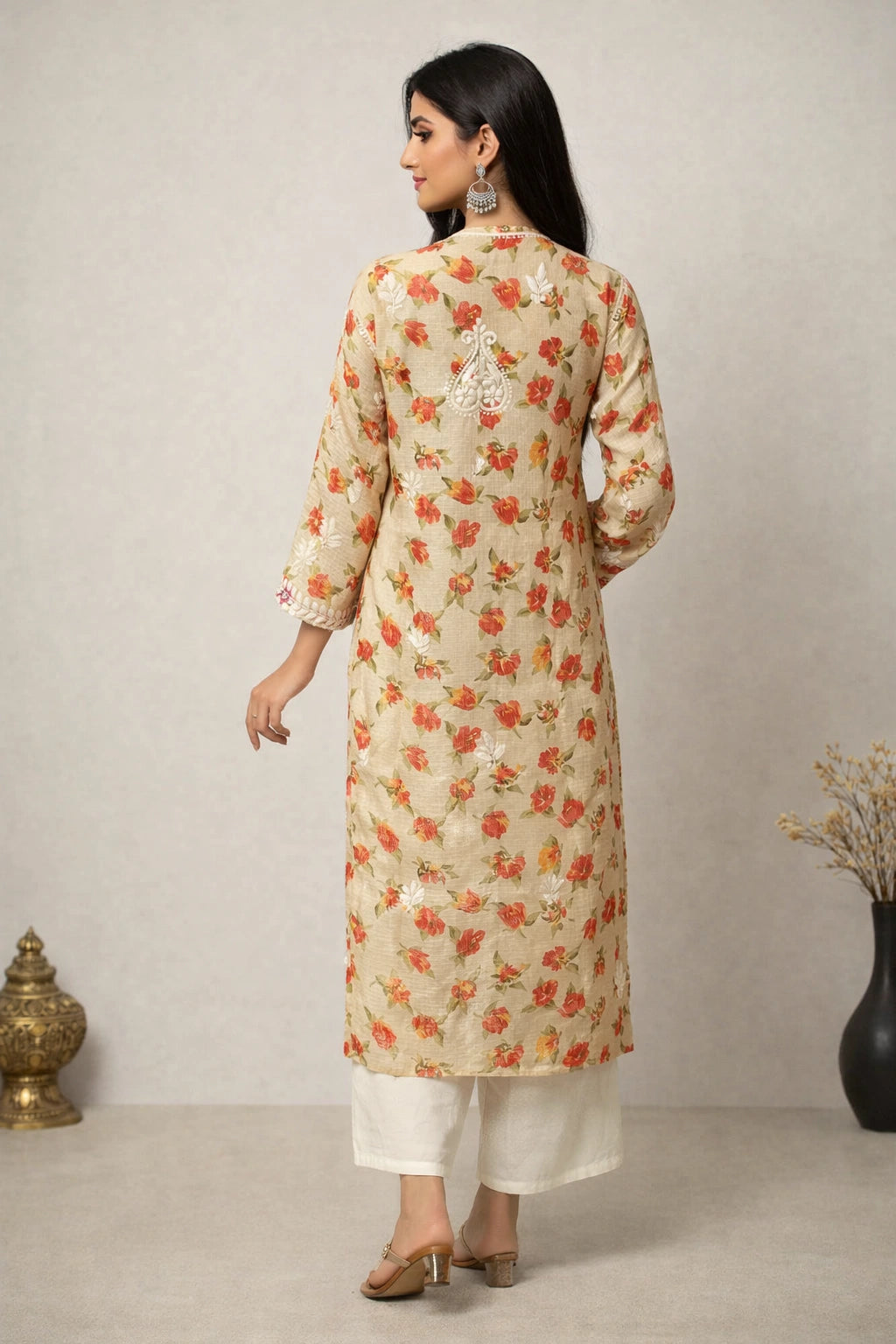 Woman wearing a floral kurta with white pants against a neutral background