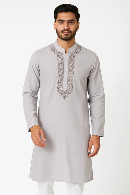 Man wearing a light gray kurta with white embroidery on a white background
