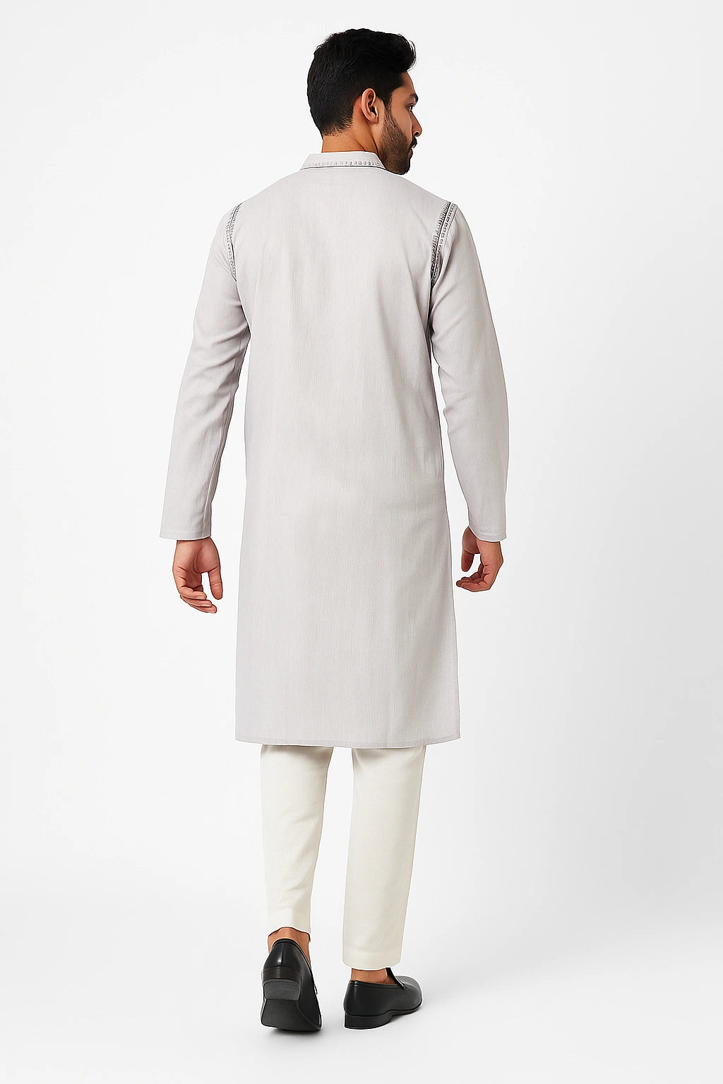 Man wearing a lucknowi chikankari light gray kurta with white pants on a white background