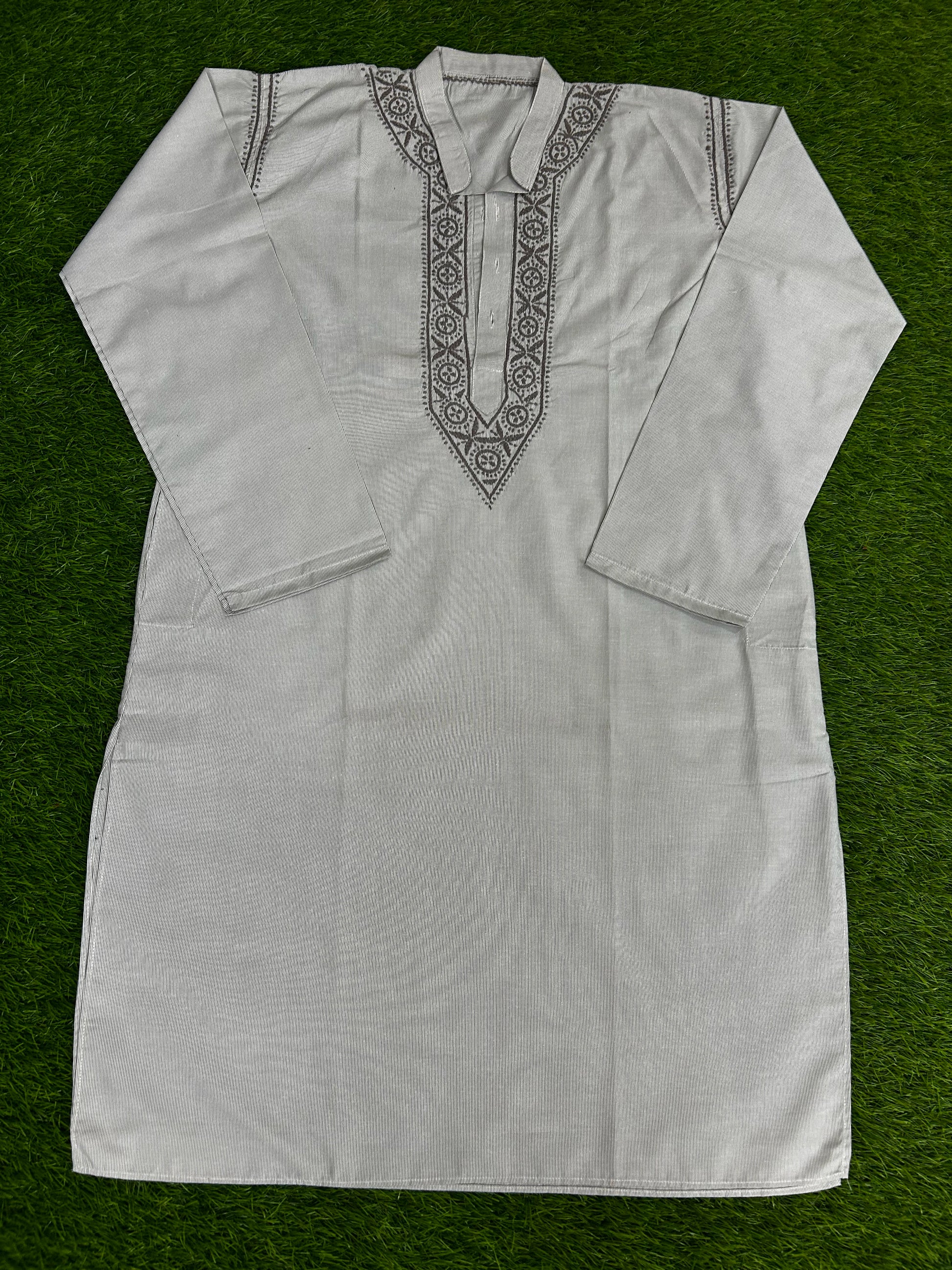 White embroidered shirt on a green background