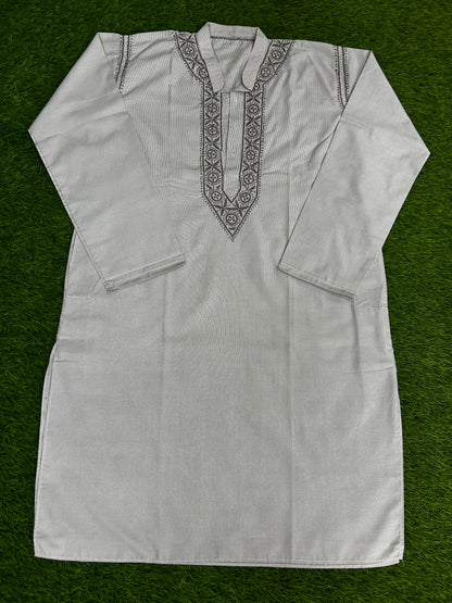 White embroidered shirt on a green background