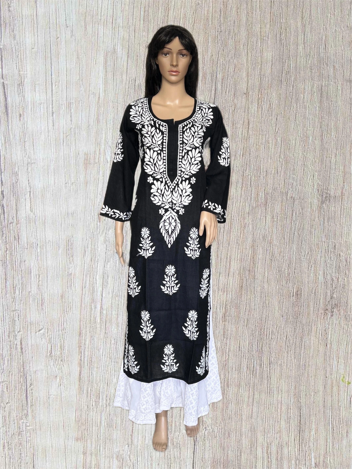Black and red embroidered dress on a mannequin against a gray background