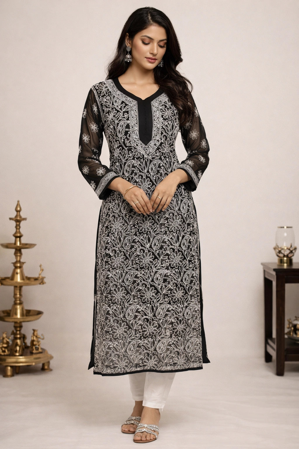 Woman wearing a black and white patterned kurta with white pants against a neutral background