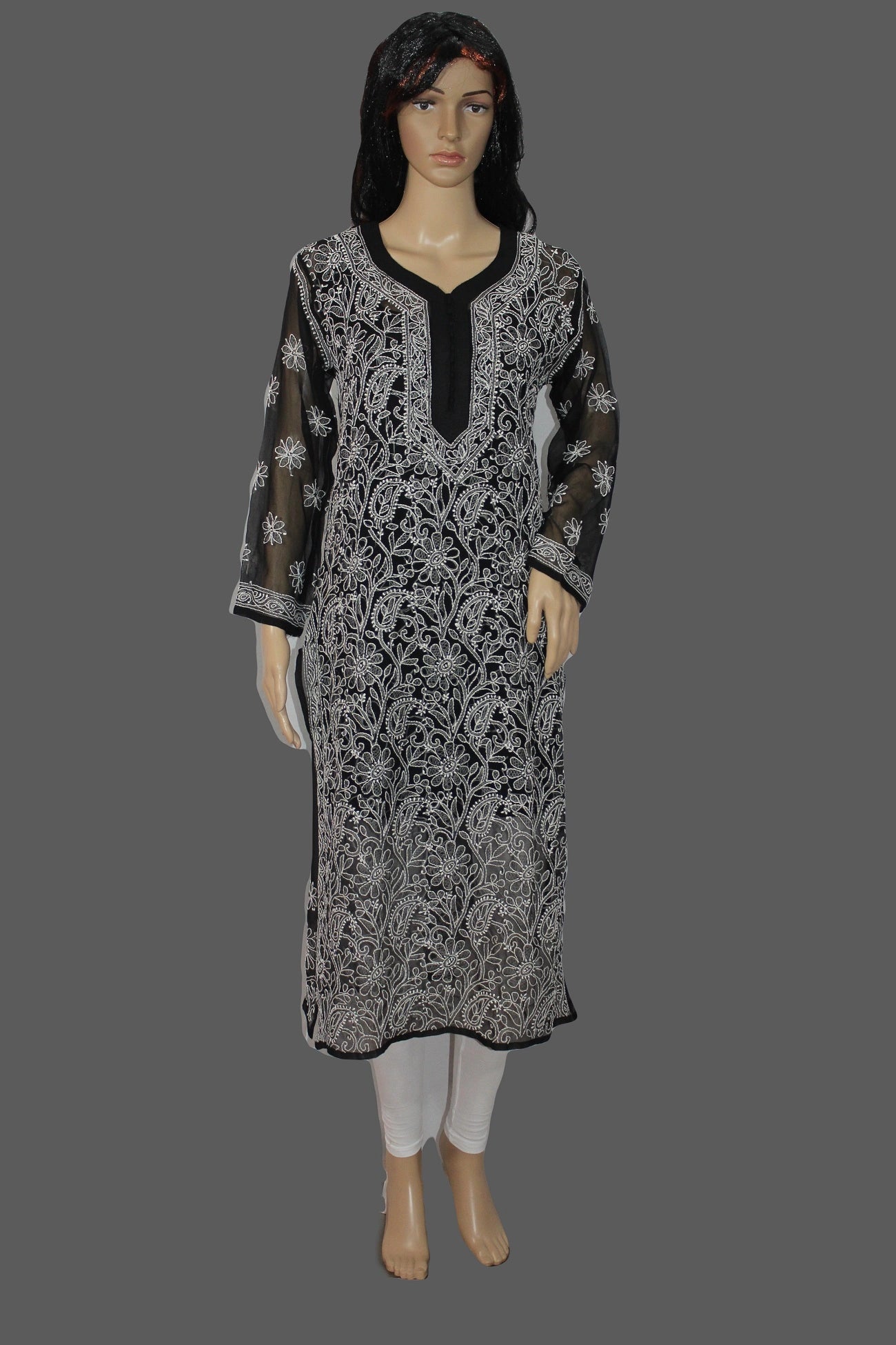 Woman wearing a black and white patterned dress on a gray background