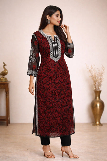Woman wearing a red and black patterned kurta with silver embroidery against a neutral background.