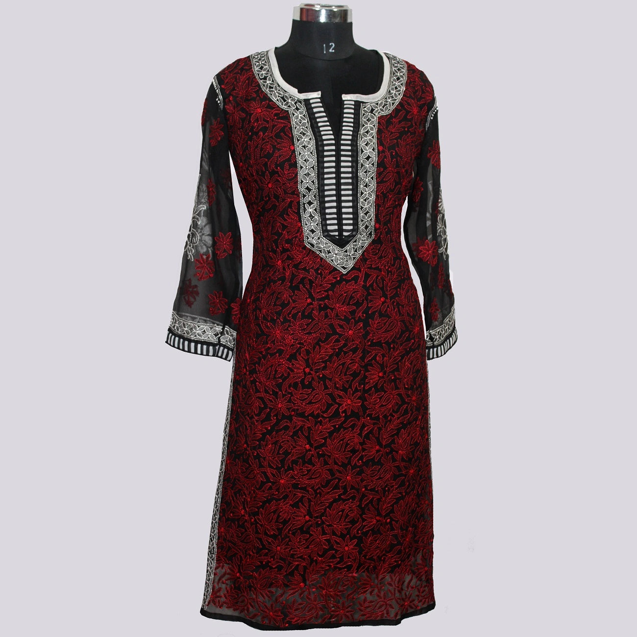 Red and black patterned dress on a mannequin against a light gray background