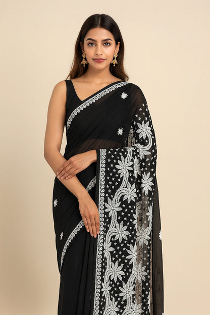 Woman wearing a lucknowi chikankari black saree with white floral patterns on a beige background